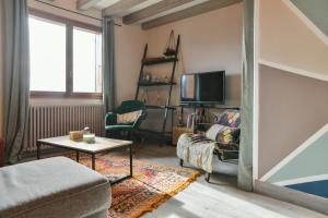 a living room with a couch and a tv at Reflets De Montagnes in Chambéry