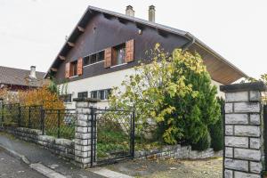 a house with a black roof and a fence at Reflets De Montagnes in Chambéry