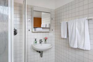 a bathroom with a sink and a mirror and towels at 1 Zimmer-appartment Nr 21 in Wangen im Allgäu +19 photos