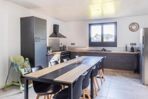 a kitchen with a large wooden table and chairs at Les petits logis de l'Écluse in Noyers-sur-Cher