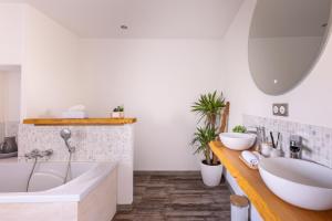 a bathroom with a large tub and a sink at Les petits logis de l'Écluse in Noyers-sur-Cher +10 photos