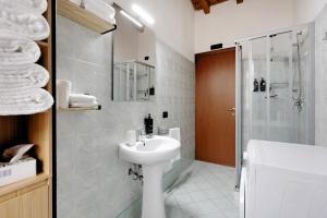 a white bathroom with a sink and a shower at Il Vagabondo in Volta Mantovana