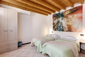 two beds in a room with a painting on the wall at Il Vagabondo in Volta Mantovana