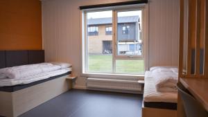 a room with a window and two beds in it at Evje Folkehøgskole in Evjemoen