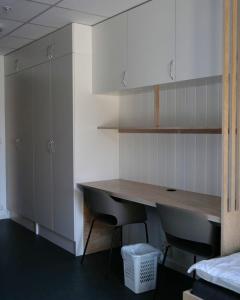 a kitchen with a wooden table and two chairs at Evje Folkehøgskole in Evjemoen