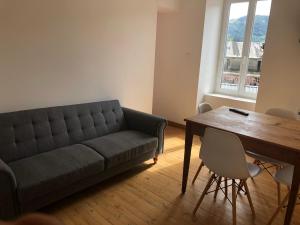 a living room with a couch and a wooden table at Appartement T 2 in La Bourboule