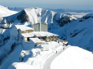 a building on top of a snow covered mountain at Appartement T 2 in La Bourboule +3 photos