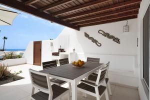 a dining room with a table and chairs at Puerto Chico E in Playa Blanca