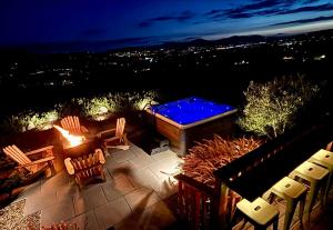 a hot tub and chairs on a patio at night at The Ultimate View - Private Spa & Fireplace in Temecula