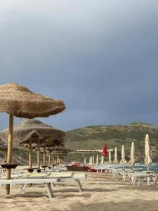 a group of chairs and umbrellas on a beach at Via Roma 50 in Bacu Abis