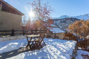 a table and chair in the snow on a house at L'Alpazen Jouve Studio Terrasse in Saint-Véran