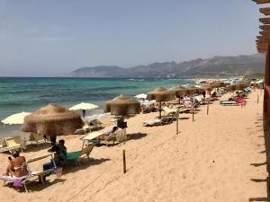 a group of people sitting on a beach with umbrellas at Via Roma 50 in Bacu Abis +21 photos