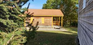 a small wooden house with yellow doors in a yard at 5 Chalet Iris in Blavignac +37 photos