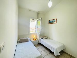 a bedroom with two beds and a window at Ville Verdi - private garden in Bibione