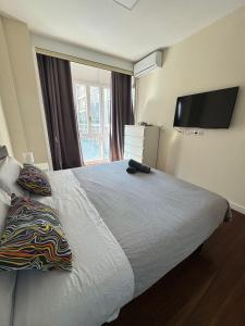 a bedroom with a large bed with a flat screen tv at Apartamento Villarias in Bilbao