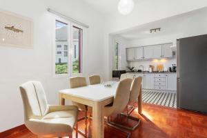a kitchen and dining room with a table and chairs at Casa Da Avó Ferreirinha in Seixal