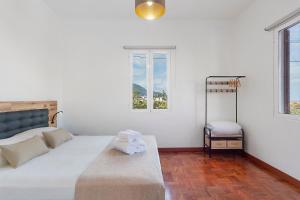 a bedroom with a bed and two windows at Casa Da Avó Ferreirinha in Seixal
