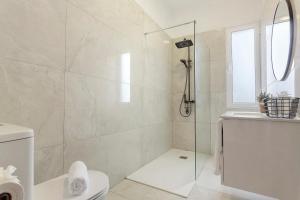 a white bathroom with a shower and a toilet at Casa Da Avó Ferreirinha in Seixal +19 photos