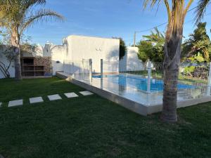 a fence around a swimming pool in a yard at La Casita de la Florida in Conil de la Frontera