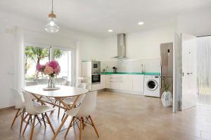 a kitchen with a table and chairs and a refrigerator at La Casita de la Florida in Conil de la Frontera