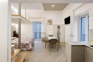 a room with a bed and a table and a kitchen at Casa Imperati in Agerola