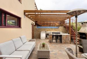 a patio with a couch and a table and a grill at Luxury 3 Beds Villa Inside Resort in Estepona
