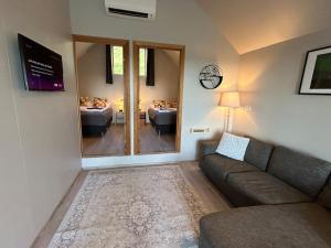a living room with a couch and a large mirror at Mountain View Apartment at Rauðafell in Hvolsvöllur