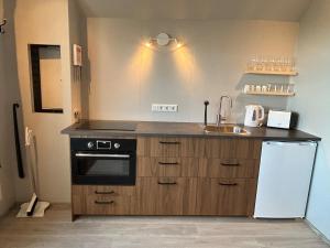 a kitchen with a sink and a stove and refrigerator at Mountain View Apartment at Rauðafell in Hvolsvöllur +8 photos