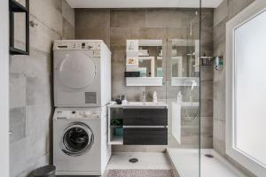 a bathroom with a washing machine and a sink at Quarto do Papagaio in Palmela