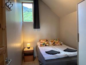 a small bedroom with a bed and a window at Mountain View Apartment at Rauðafell in Hvolsvöllur
