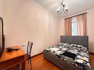 a bedroom with a bed and a table and a desk at Republic Square FAMILY 2 bedroom 2 bathroom in Yerevan