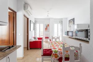 a small kitchen and living room with a red couch at Apartamento Pintada 25 in Nerja