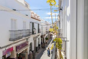 a city street with buildings and people walking down it at Apartamento Pintada 25 in Nerja