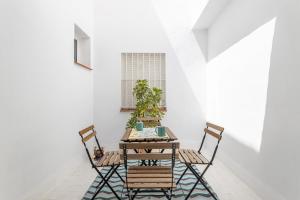 a table and chairs in a room with white walls at Apartamento Pintada 25 in Nerja +12 photos