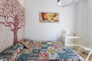 a bedroom with a bed with a tree on the wall at Apartamento Pintada 25 in Nerja