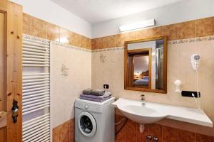 a bathroom with a sink and a washing machine at La Coccinella Livigno in Livigno +33 photos