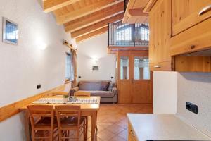 a kitchen and living room with a table and a couch at La Coccinella Livigno in Livigno