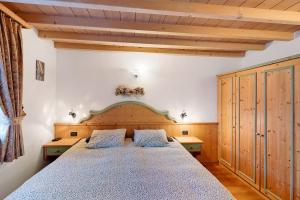 a bedroom with a large bed and wooden ceilings at La Coccinella Livigno in Livigno