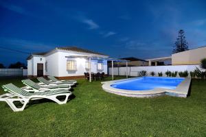 a group of chairs sitting next to a swimming pool at Chalet Isla del Sotillo in Chiclana de la Frontera