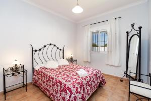 a bedroom with a bed with a red bedspread at Chalet Isla del Sotillo in Chiclana de la Frontera +30 photos