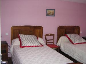 a bedroom with two beds with red pillows at Gite La Lavande in Peyreleau