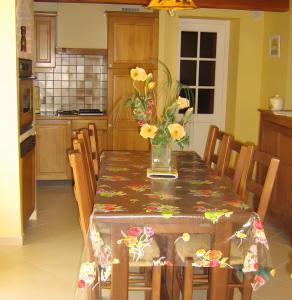 a kitchen with a table with a vase of flowers on it at Gite La Lavande in Peyreleau