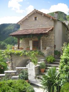a small house with a white fence in front of it at Gite La Lavande in Peyreleau