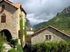 an old stone building with a mountain in the background at Gite La Lavande in Peyreleau