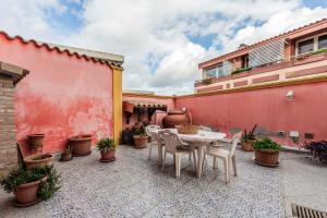 a patio with a table and chairs and plants at Red House Capoterra in Capoterra