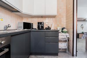 a kitchen with a sink and a microwave at Red House Capoterra in Capoterra