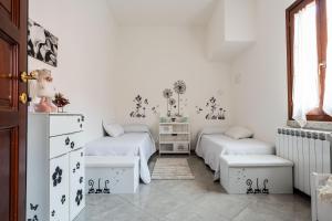 a white room with two beds and a window at Red House Capoterra in Capoterra