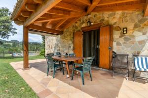 a wooden table and chairs on a patio at Casa La Granja in Olvan