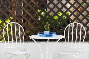 two white chairs and a table with a plant on it at Seaside House In Agios Vasilios in Patra