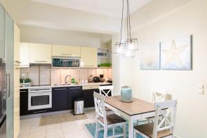 a kitchen with a table and a dining room at Seaside House In Agios Vasilios in Patra